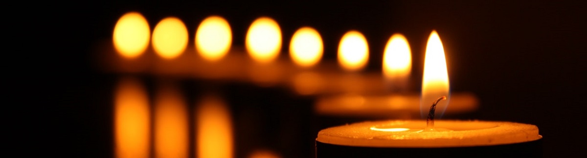 close up of a row of candle flames in a dark room