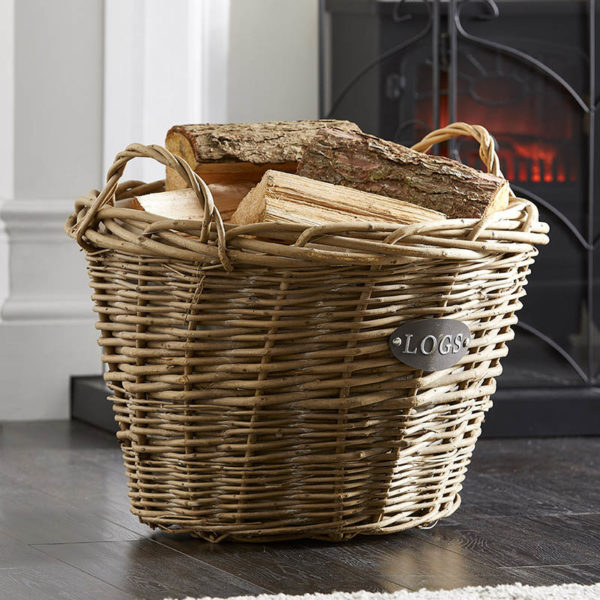 wholesale wicker log basket with handles filled with logs stand in front of a lit stove fire