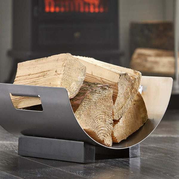 wholesale ironware log basket with a curved design is shown holding logs in front of a stove fire