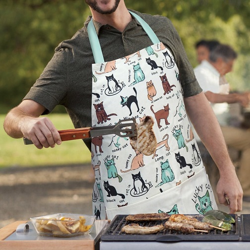 Man in a coking apron stood in front of a barbique