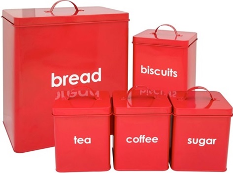 A collection of metal kitchen containers painted red including bread, biscuits, tea, coffee and sugar